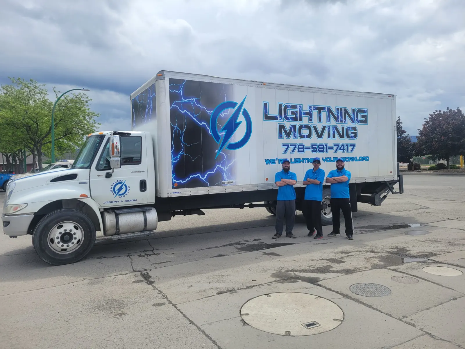The Team Lightning crew of three standing beside their box truck in Kamloops